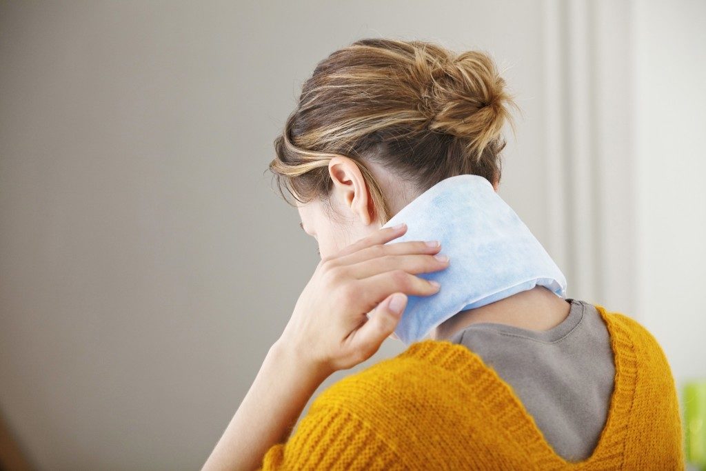 Woman putting ice pack in her neck