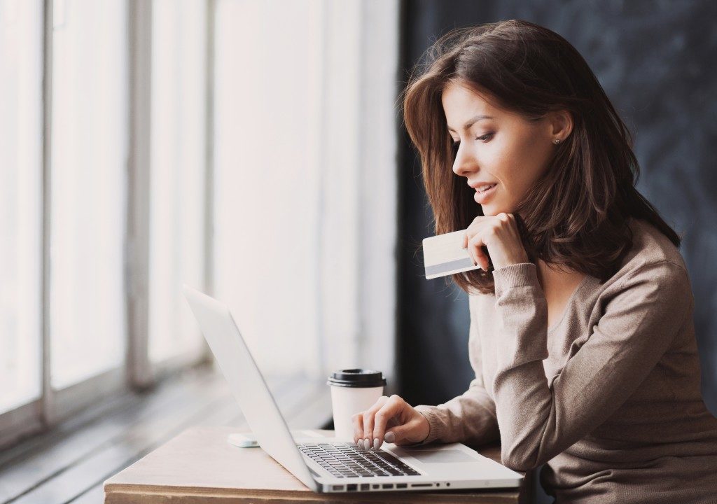 attractive woman paying using her credit card