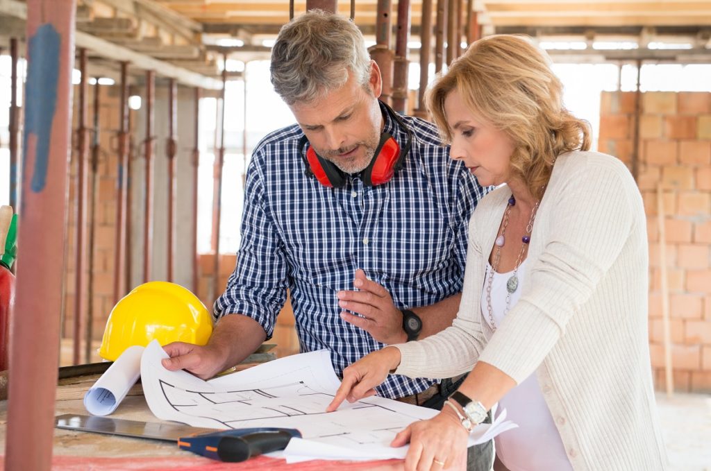 man and woman looking at house plans