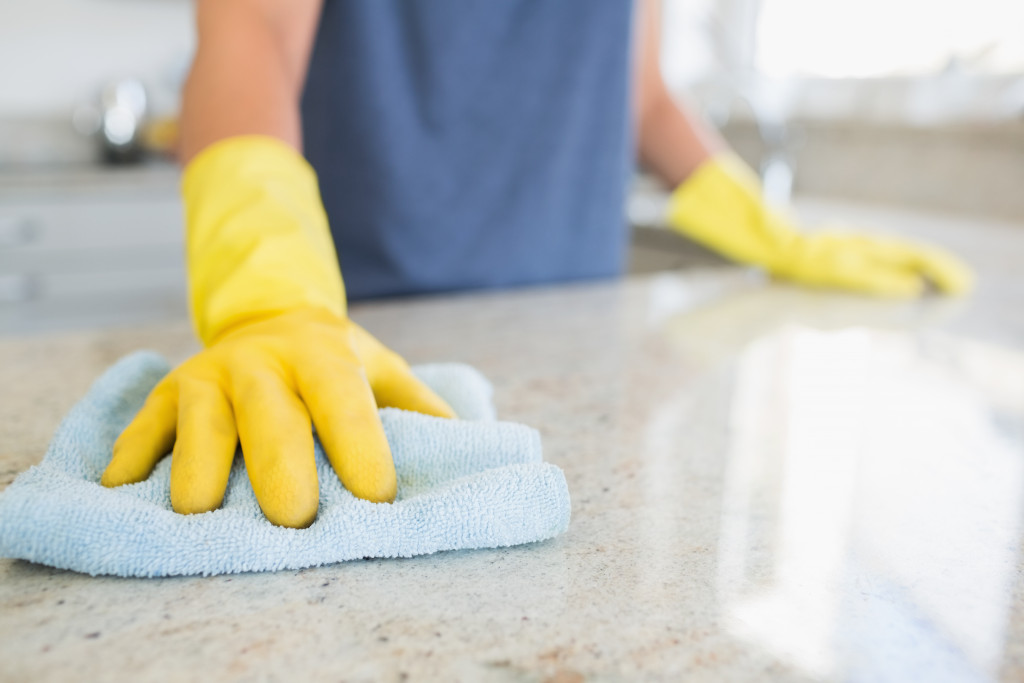 A person cleaning the kitchen counter